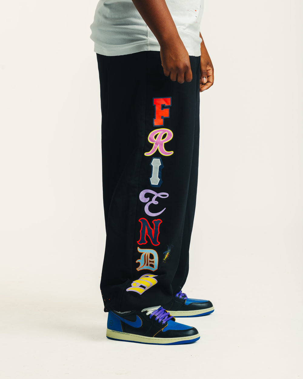 Side view of the black Friends Sweats showing the colorful Friends lettering down the leg