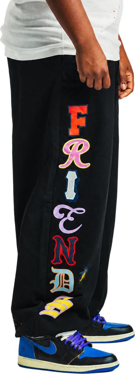 On-body side view of black Friends Sweats showing colorful lettering down the leg